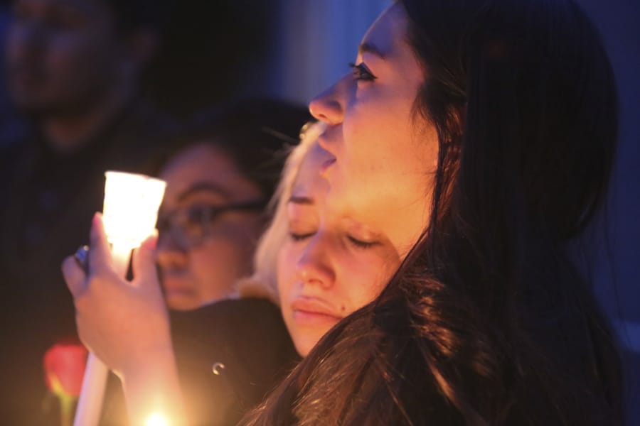 FILE - In this March 5, 2020, file photo, Isis and Alexis Valenzuela, daughters of Antonio Valenzuela, hug each other during a candlelight vigil in Las Cruces, N.M. Antonio Valenzuela was killed by a Las Cruces police officer in February. As national Black Lives Matter demonstrations grow, Latino activists are joining the multiracial protests while trying to draw attention to their deadly police encounters, some of which go back decades.