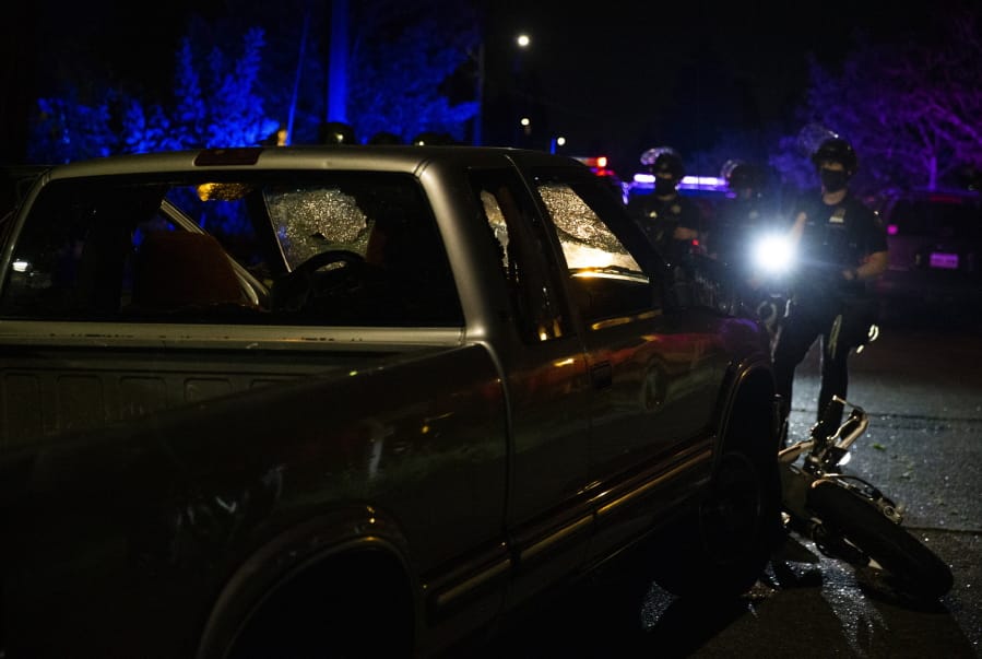 A pickup truck was abandoned several blocks west after its driver accelerated towards the crowd, hitting and dragging a motorcycle during a protest in Portland, Ore., on Tuesday, Aug. 4, 2020.
