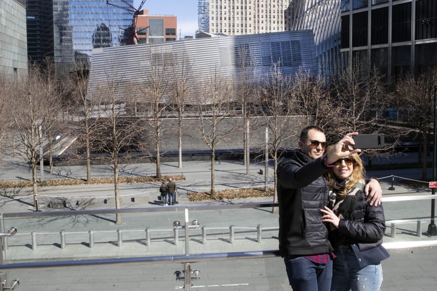 FILE - In this March 4, 2020 file photo Paul and Michelle Connolly, of Yorkshire, England, take a selfie above the closed National September 11 Memorial &amp; Museum, in New York.  Nearly six months after the coronavirus forced its closure, the 9/11 Memorial Museum will be reopening on the anniversary of the terrorist attacks next month. The memorial plaza had been open to the public with social distancing restrictions since early July, but the museum remained closed as did other cultural institutions.