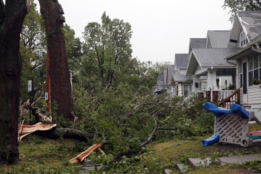 Downed trees and other debris cover front yards in Cedar Rapids, Iowa, after a powerful storm moved through Iowa on Monday, Aug. 10, 2020.
