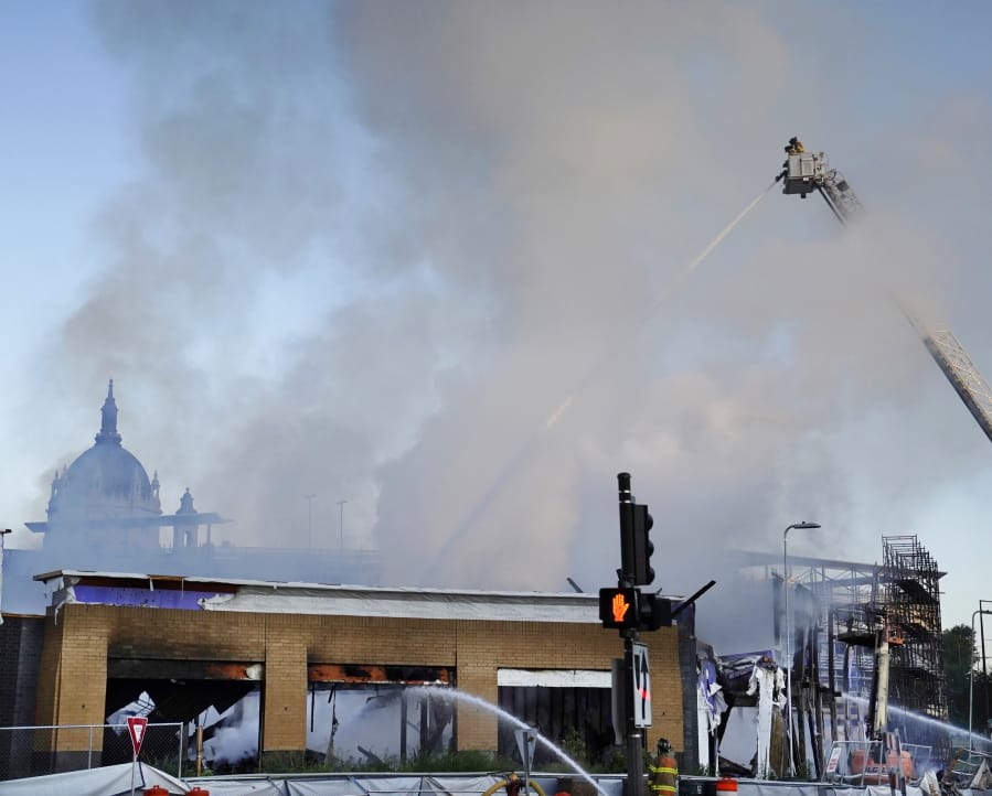 Firefighters battle a fire in downtown St. Paul, Minn., that has engulfed a building that was under construction on Tuesday, Aug. 4, 2020. There were no reports of injuries and there was no immediate word about the possible cause of the fire.