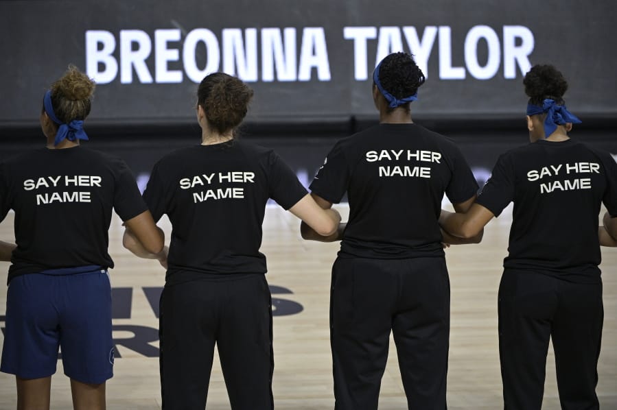 Minnesota Lynx players lock arms during a moment of silence in honor of Breonna Taylor before a WNBA basketball game against the Connecticut Sun, Sunday, July 26, 2020, in Bradenton, Fla. (AP Photo/Phelan M.