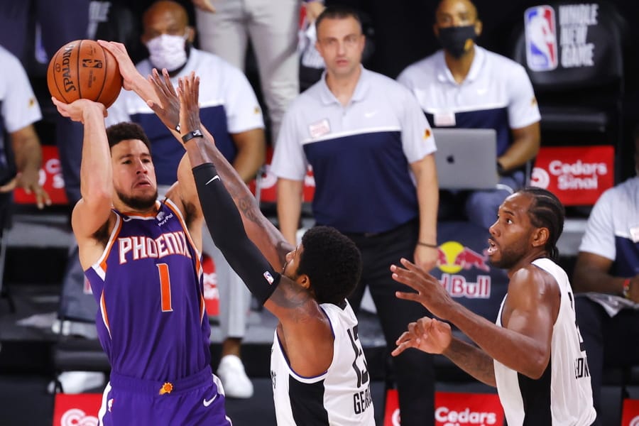 Phoenix Suns&#039; Devin Booker shoots the game-winning basket over Los Angeles Clippers&#039; Paul George (13) in an NBA basketball game Tuesday, Aug. 4, 2020, in Lake Buena Vista, Fla. (Kevin C.