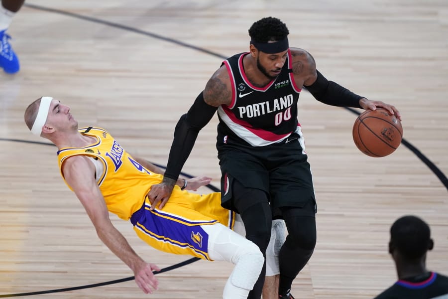 Los Angeles Lakers guard Alex Caruso (4) falls to the court defending Portland Trail Blazers forward Carmelo Anthony (00) during the second half of an NBA basketball game Tuesday, Aug. 18, 2020, in Lake Buena Vista, Fla.