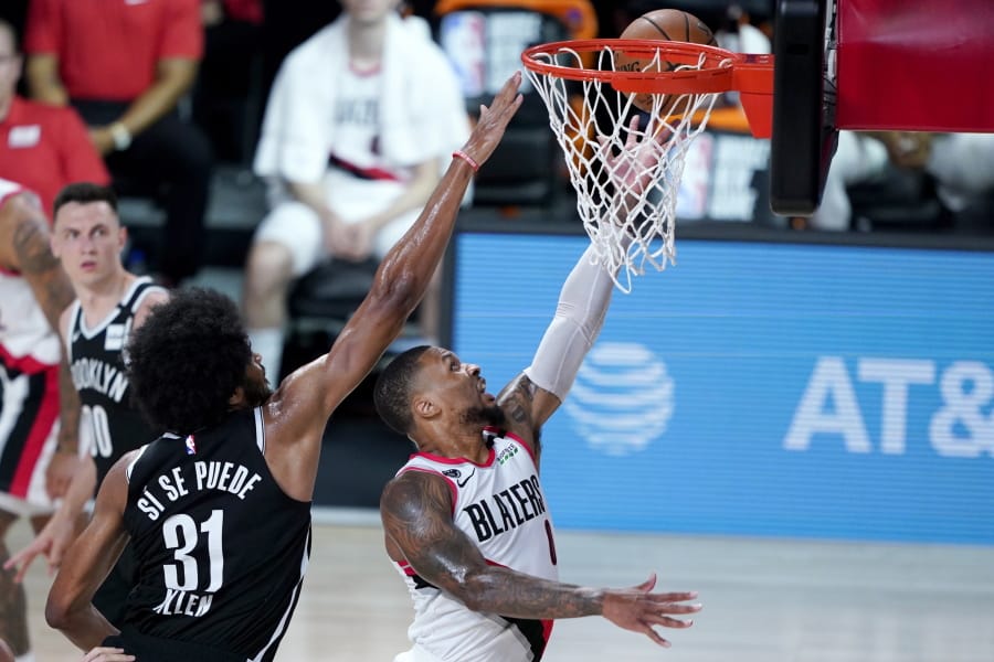 Portland Trail Blazers&#039; Damian Lillard, right, goes up for a shot against Brooklyn Nets&#039; Jarrett Allen (31) during the first half of an NBA basketball game Thursday, Aug. 13, 2020 in Lake Buena Vista, Fla.