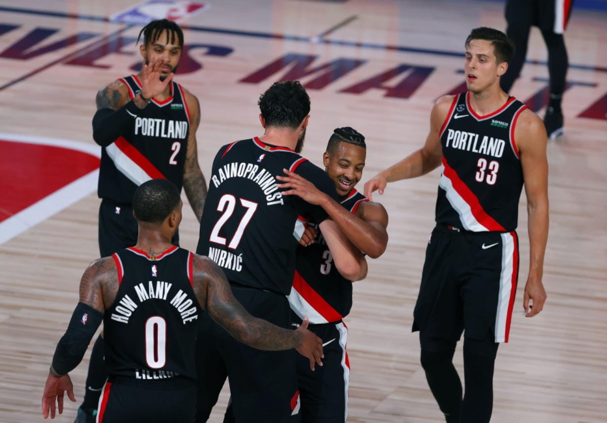 Portland Trail Blazers&#039; CJ McCollum, second from right, and Jusuf Nurkic (27) celebrate their 125-115 win over the Denver Nuggets in an NBA basketball game Thursday, Aug. 6, 2020, in Lake Buena Vista, Fla. (Kevin C.