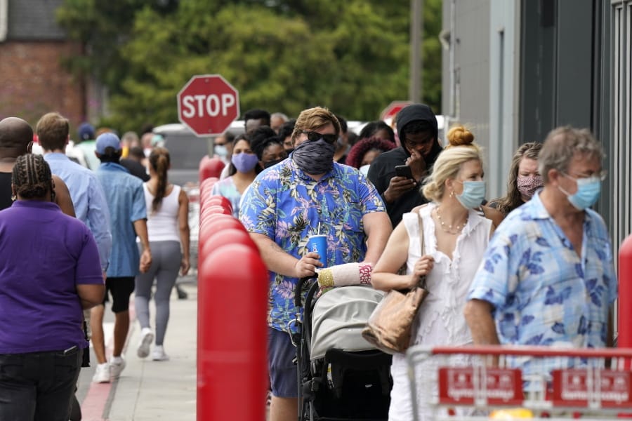 People line up to enter retail chain Costco to buy provisions in New Orleans, Sunday, Aug. 23, 2020, in advance of Hurricane Marco, expected to make landfall on the Southern Louisiana coast.