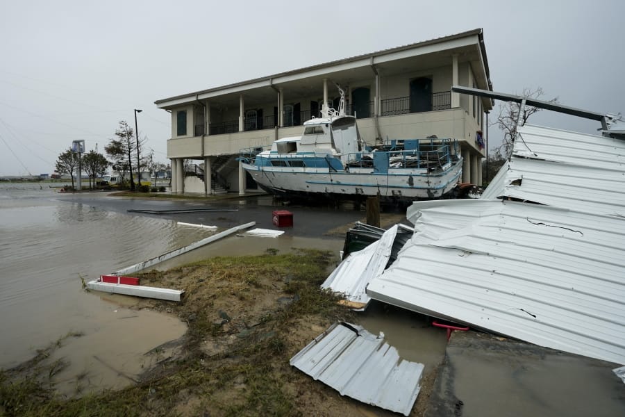 Flooding surrounds a damaged building and boat Friday, Aug. 28, 2020, in Cameron, La., after Hurricane Laura moved through the area Thursday. (AP Photo/David J.