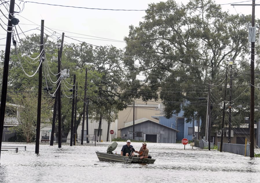 Boaters navigate a flooded road following Hurricane Laura, Thursday, Aug. 27, 2020 in Delcambre, La.