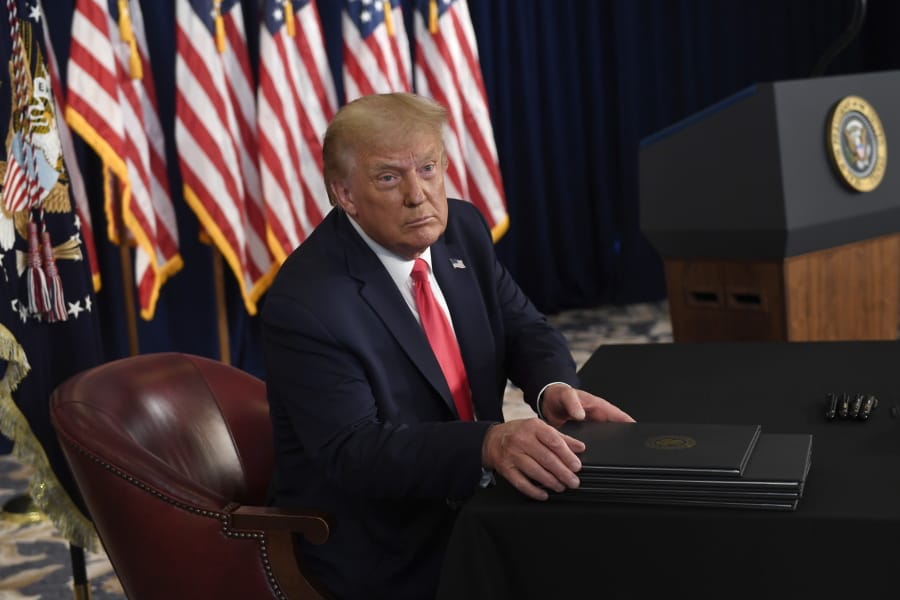 President Donald Trump prepares to sign four executive orders during a news conference at the Trump National Golf Club in Bedminster, N.J., Saturday, Aug. 8, 2020.