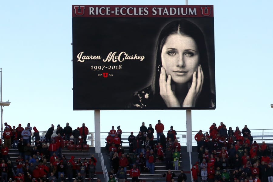 FILE - In this Nov. 10, 2018, file photo, a photograph of University of Utah student and track athlete Lauren McCluskey, who was fatally shot on campus, is projected on the video board before the start of an NCAA college football game between Oregon and Utah in Salt Lake City. An investigation found Wednesday, Aug. 5, 2020, that a group of University of Utah police officers made inappropriate comments about explicit photos of McCluskey, who had submitted the pictures as evidence in an extortion case shortly before her shooting death. The findings came after the Salt Lake Tribune unearthed allegations that an officer had bragged about having the images of McCluskey before her 2018 slaying.