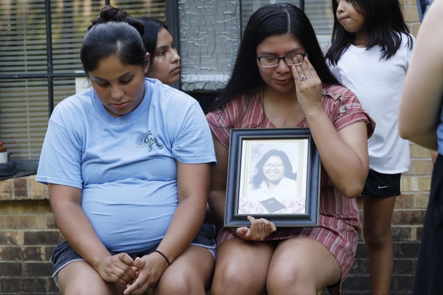 Kristina Taylor, 18, cries as she holds a portrait of her late mother, Sharon Taylor, while she and her older sister Kristi Wishork, 25, recall the care their mother had for her children and grandchildren, Tuesday, July 21, 2020 at their home in Tucker, Miss. Taylor, 53, died of coronavirus at the University of Mississippi Medical Center in Jackson on June 26 after two weeks in the hospital. She never saw her daughter Kristina, the class valedictorian at Choctaw Central High School, graduate. (AP Photo/Rogelio V.