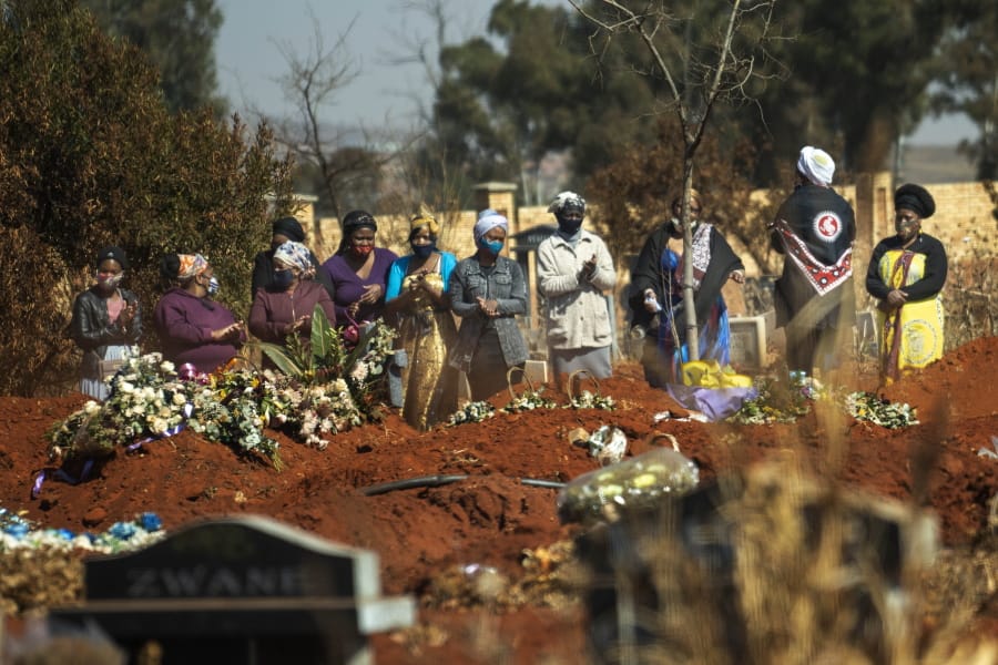 Mourners pray during a burial ceremony Thursday at the Olifantsveil Cemetery outside Johannesburg, South Africa. The frequency of burials in South Africa has significantly increased during the coronavirus pandemic.