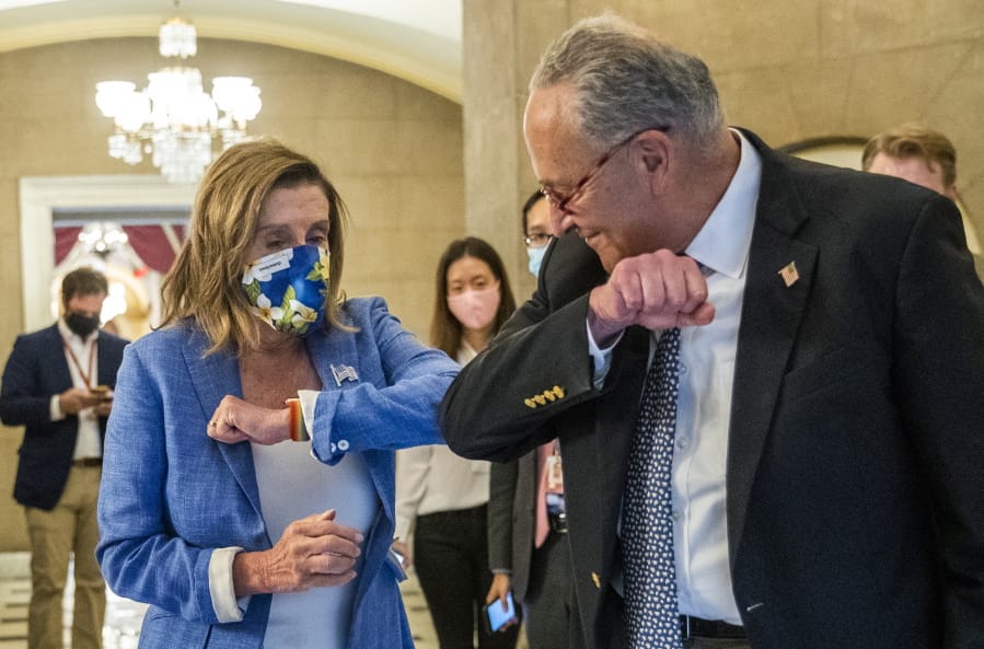 House Speaker Nancy Pelosi of Calif., gives Senate Minority Leader Chuck Schumer of N.Y., an elbow bump as Schumer leaves following a meeting at the Capitol with White House chief of staff Mark Meadows and Treasury Secretary Steven Mnuchin on a COVID-19 relief bill, Saturday, Aug. 1, 2020, in Washington.