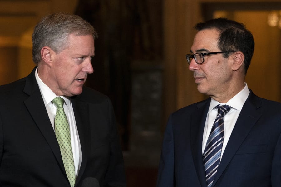 Treasury Secretary Steven Mnuchin and White House chief of staff Mark Meadows look to each other as they speak to reporters on Capitol Hill in Washington, Thursday, Aug. 6, 2020.