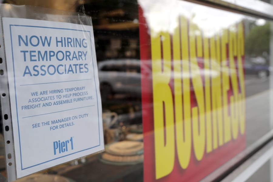 A sign advertises hiring of temporary associates at a Pier 1 retail store, which is going out of business, during the coronavirus pandemic, Thursday, Aug. 6, 2020, in Coral Gables, Fla. The home goods retailer is going out of business and is permanently closing all of its stores.