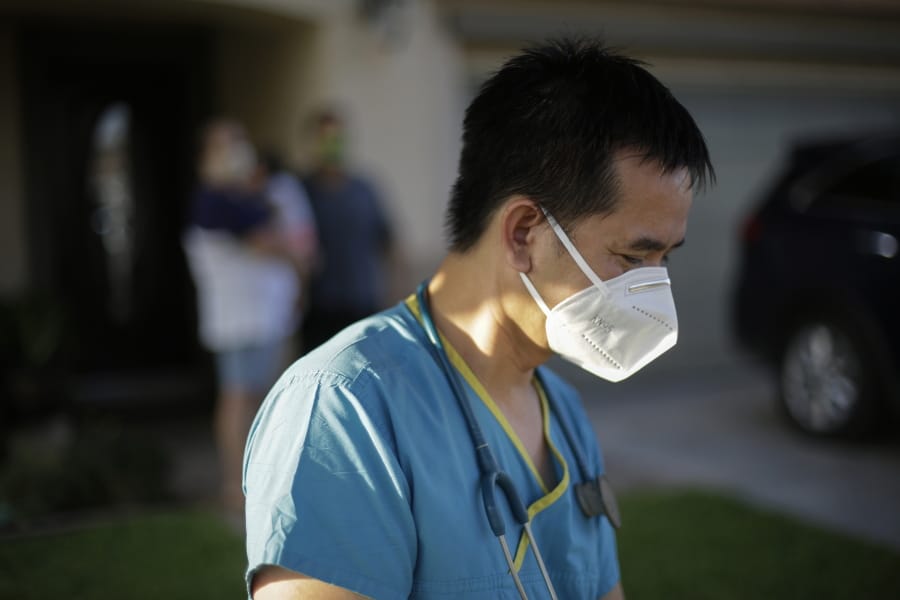Dr. Tien Vo goes to leave after talking with a family quarantining after they tested positive for the coronavirus Thursday, July 23, 2020, in Calexico, Calif. Vo and members of his clinic bring food to patients that test positive and agree to quarantine.