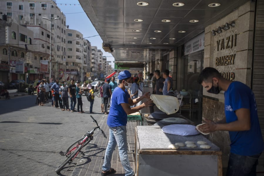 Palestinians line up in front of a bakery to buy bread during a 48 hour lockdown imposed following the discovery of the first coronavirus cases in the Gaza Strip, Tuesday, Aug. 25, 2020.