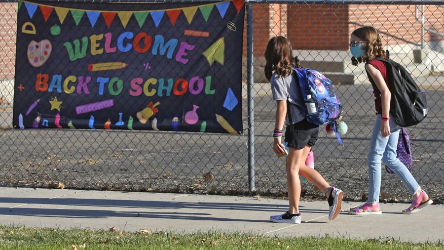Cimmie Hunter, left, and Cadence Ludlow, both sixth graders, arrive at Liberty Elementary School for the first day of class Monday in Murray, Utah.