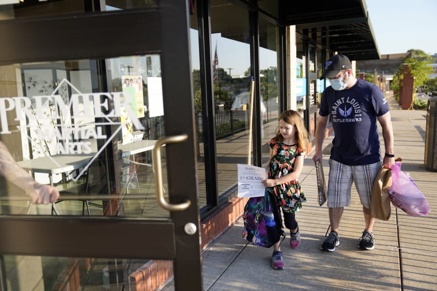Paul Quisenberry drops his daughter Audra, 6, off at Premier Martial Arts on her first day of school Monday, Aug. 24, 2020, in Wildwood, Mo. The first grader will attend her classes virtually while spending her days at the martial arts studio because her school is shut down due to COVID-19.