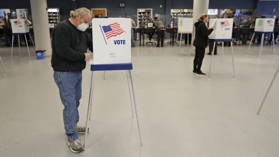 This Tuesday, April 28, 2020 file photo shows Jerome Fedor, left, voting using social distancing at the Cuyahoga County Board of Elections, in Cleveland, Ohio. Ohio&#039;s elections chief says his office plans to remove about 120,000 inactive Ohio voter registrations from state voter rolls after the November election.