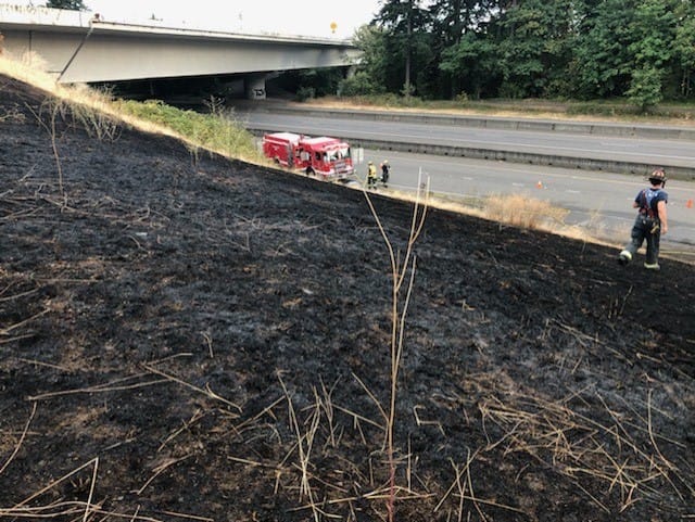 A vehicle fire on state Highway 14 spread to nearby grass Wednesday evening, burning about an acre before being brought under control by the Vancouver Fire Department.