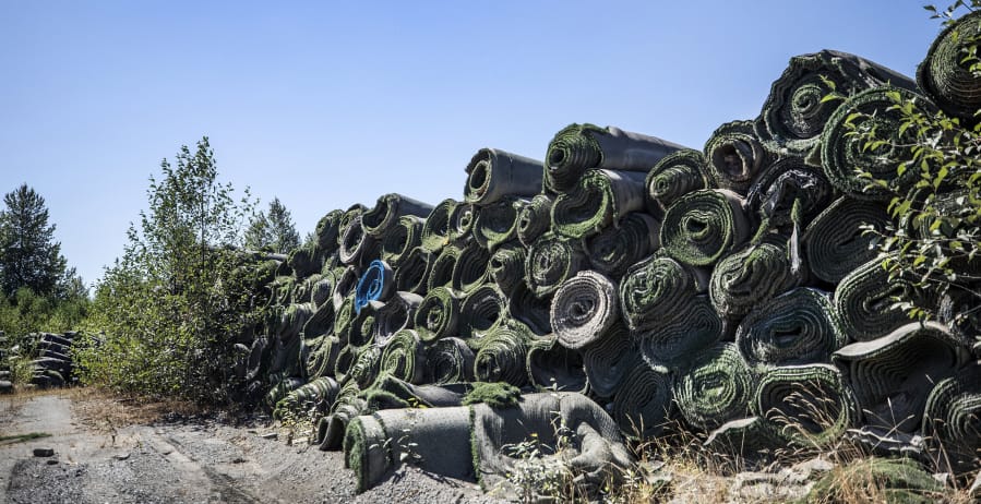 Piles of old FieldTurf are stored near the Puyallup River. FieldTurf was used for a recent retrofit for the liner of the Electron Hydropower Project.