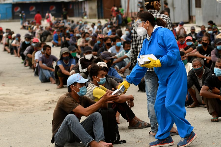 Volunteers distribute food packets people in need after a week-long restrictions were imposed by district officials to contain the spread of the Covid-19 coronavirus, in Kathmandu on August 31, 2020.