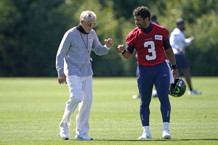 Seattle Seahawks quarterback Russell Wilson (3) bumps fists with head coach Pete Carroll after practice last week in Renton. With Wilson in the prime of his career and surrounded by weapons on offense, the Seahawks are once again contenders in the NFC. (Ted S.