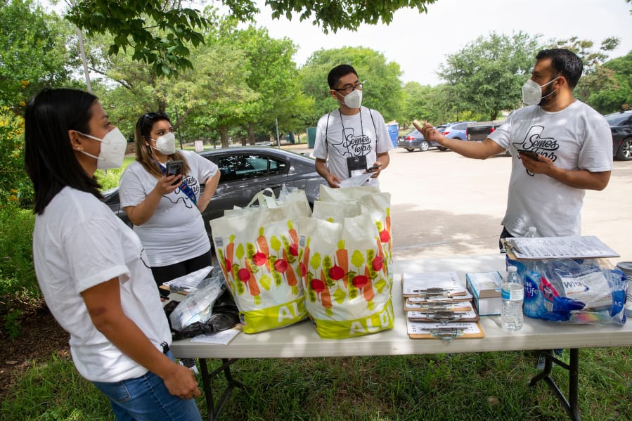 Ramiro Luna-Hinojosa, right, speaks to members of Somos Tejas at Martin Weiss Park before they go door to door in the Oak Cliff neighborhood educating people on COVID-19, the census and voting on June 27, 2020, in Dallas.