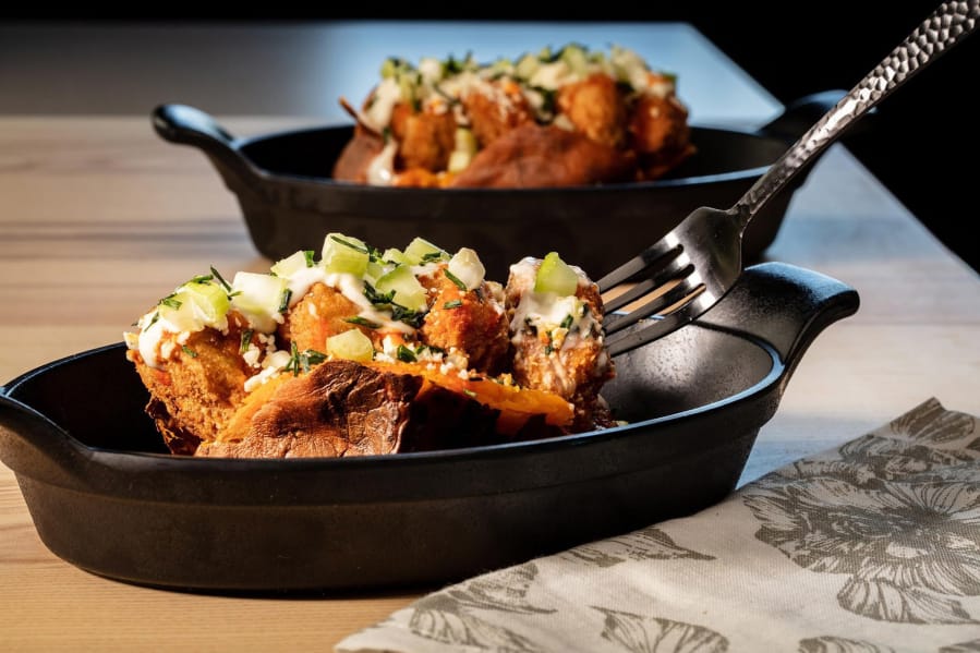 The classic idea of a loaded baked potato becomes dinner all by itself. Here sweet potatoes take the place of russets, and Buffalo chicken wings inspire the toppings.
