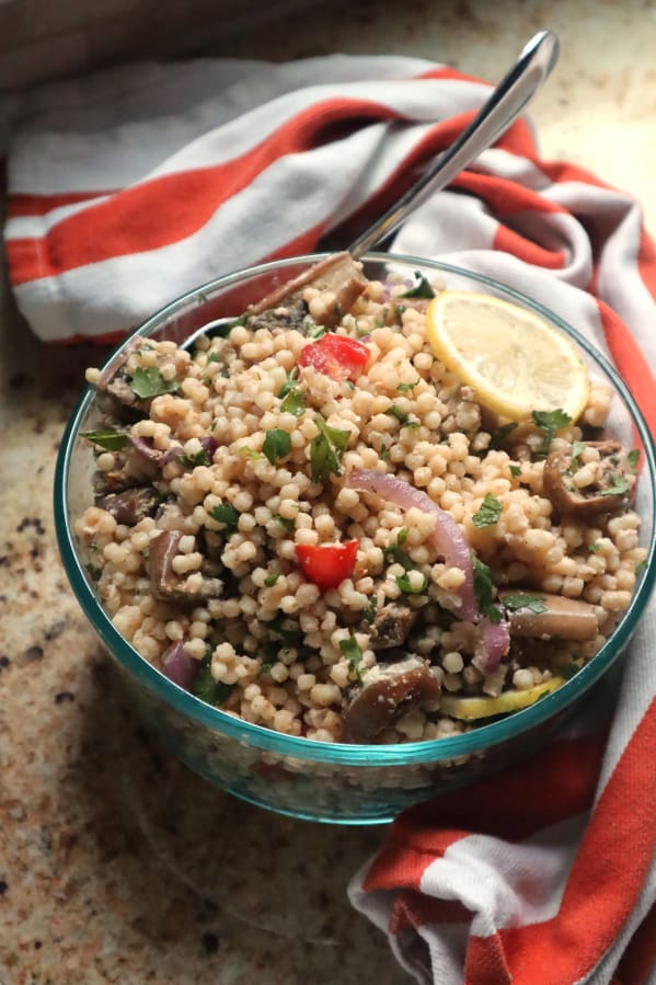 Roasted eggplant is tossed with Isaeli couscous, tomatoes, fresh herbs and a lemony tahini dressing.