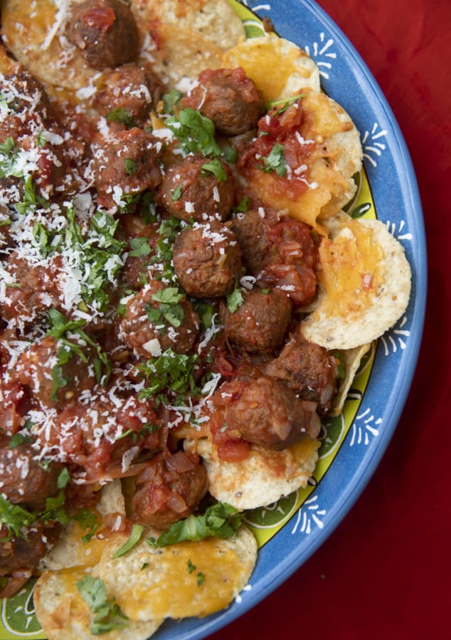 Nachos with meatballs features two crowd-pleasers packed as one hearty snack. Pork meatballs are dunked into a chunky salsa and served on cheesy tortilla chips.