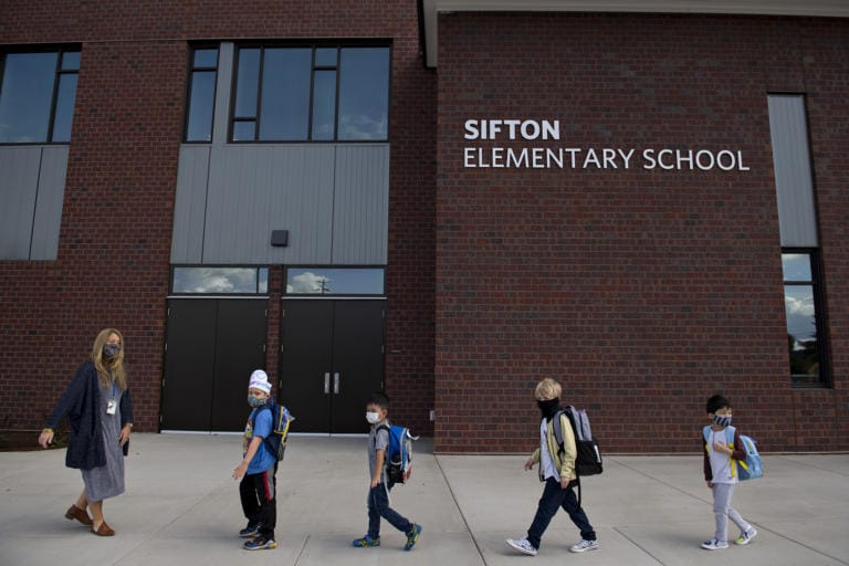 Kindergarten teacher Katie Plamondon, from left, leads students Phoenix Winmil, 5, Wes Charuchinda, 5, Emery Thomas, 6, and Jay Chou, 6, into the building for their second day of classes at Sifton Elementary School on Tuesday afternoon, Sept. 22, 2020.