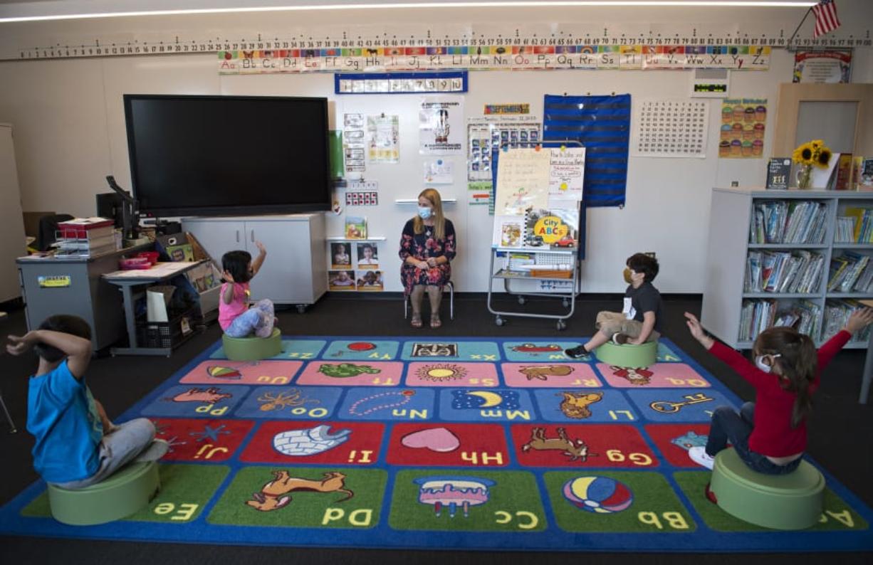Kindergarten teacher Pam Younkin, center, leads students at the start of class at Sifton Elementary School on Tuesday afternoon. Transmission rates in Clark County are again too high for a widespread return to the classroom. While small groups like this are considered safe, state health guidelines recommend that schools with high rates of COVID-19 activity continue virtual learning.