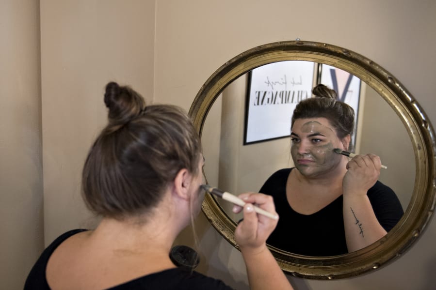 Salon manager Alex James demonstrates an Epicuren green tea and seaweed smoothing mask at Glam Beauty Bar in downtown Vancouver. James and other spa staff normally wear masks while in the salon.