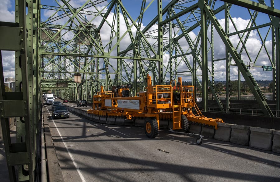 The zipper machine makes its way across the Interstate 5 Bridge to adjust the central barrier and reverse the middle lane of traffic shortly after noon Tuesday.