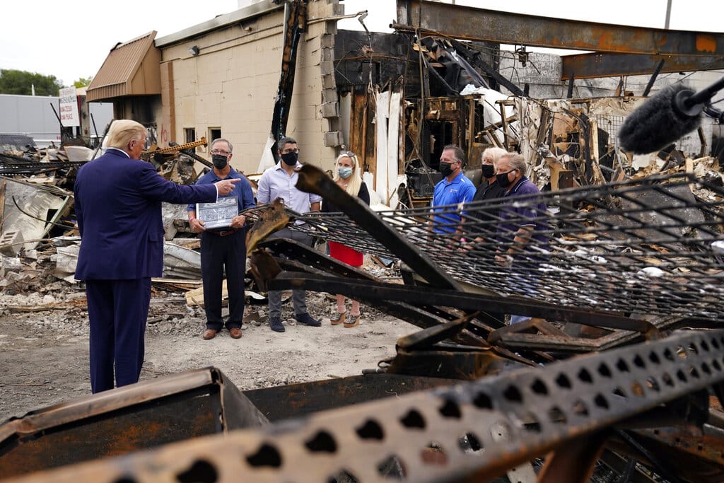 President Donald Trump talks to business owners Tuesday, Sept. 1, 2020, as he tours an area damaged during demonstrations after a police officer shot Jacob Blake in Kenosha, Wis.