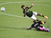 Portland Timbers midfielder Eryk Williamson, left, is upended by Seattle Sounders defender Nouhou Tolo during the first half of an MLS soccer match in Portland, Ore., Wednesday, Sept. 23, 2020.