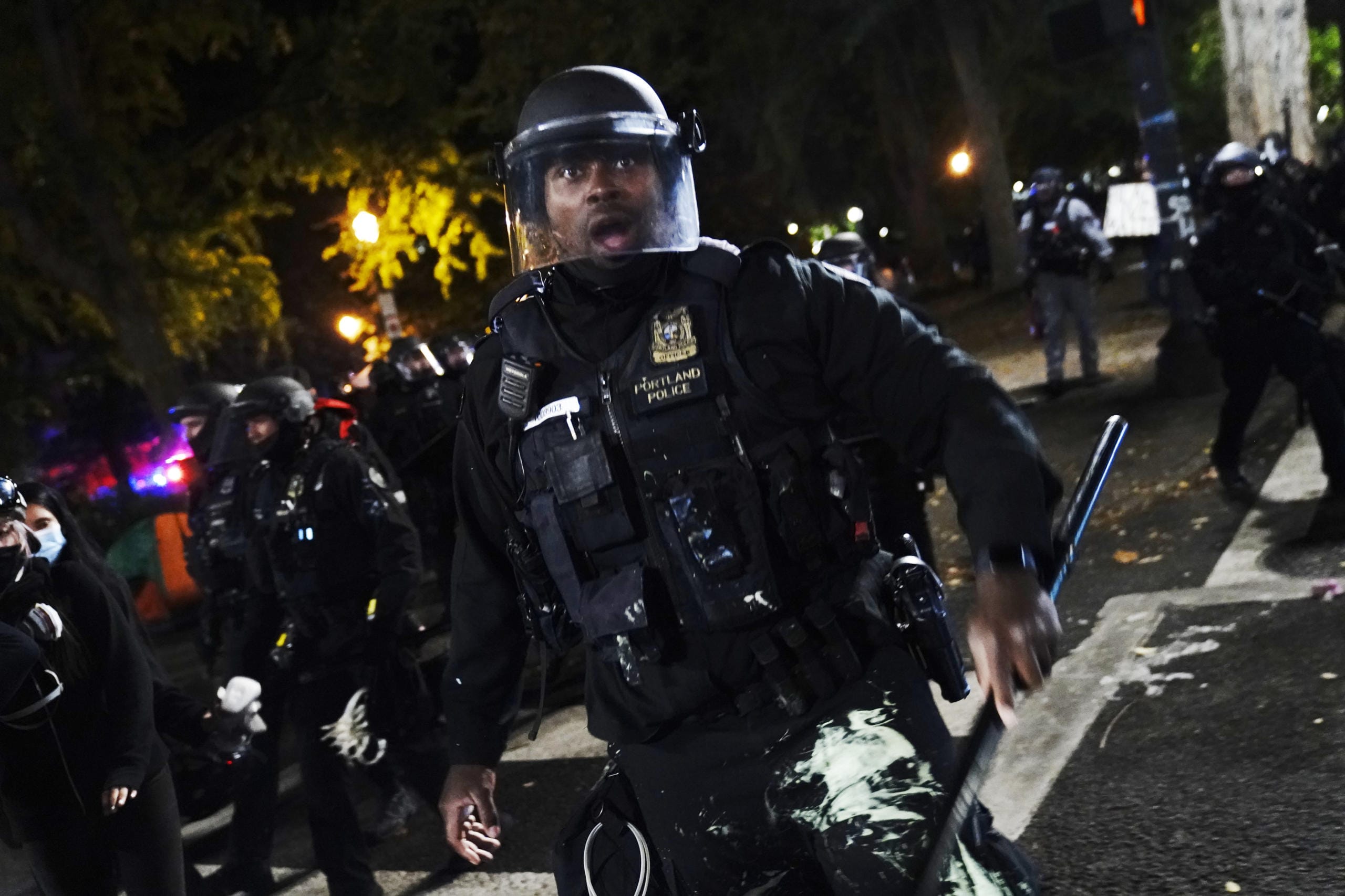 A Portland police officer pushes back protesters, Saturday, Sept. 26, 2020, in Portland. The protests, which began over the killing of George Floyd, often result frequent clashes between protesters and law enforcement.