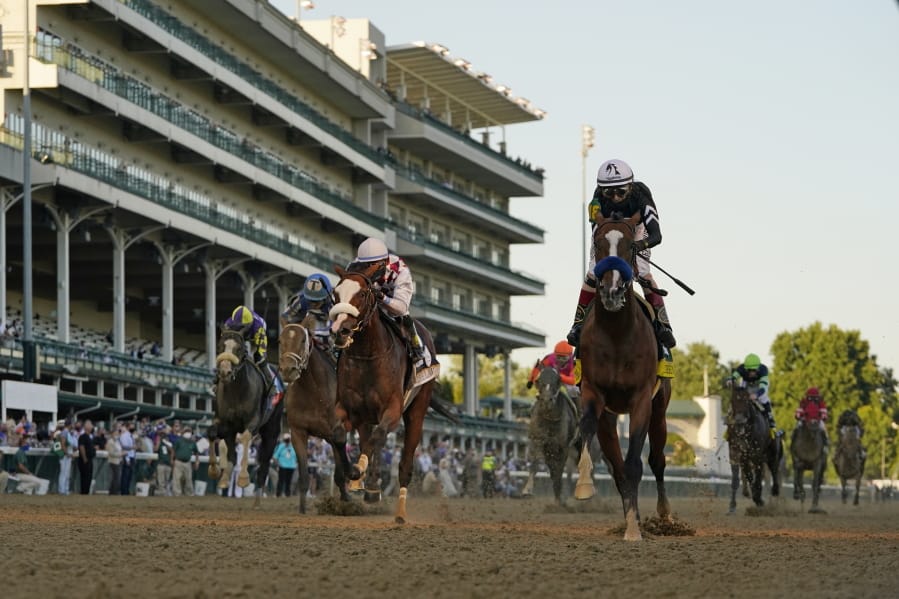 Jockey John Velazquez riding Authentic, right, crosses the finish line to win the 146th running of the Kentucky Derby at Churchill Downs, Saturday, Sept. 5, 2020, in Louisville, Ky.