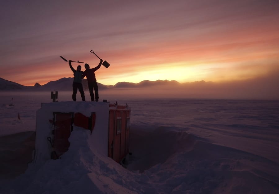 In this handout photo provided by British Antarctic Survey, field guides Sarah Crowsley, left, and Sam Hunt, right, pose for a photo after digging out the caboose, a container used for accommodation that can be moved by a tractor, at Adelaide island, in Antarctica on Friday, June 19, 2020. Antarctica remains the only continent without COVID-19 and now in Sept. 2020, as nearly 1,000 scientists and others who wintered over on the ice are seeing the sun for the first time in months, a global effort wants to make sure incoming colleagues don&#039;t bring the virus with them.