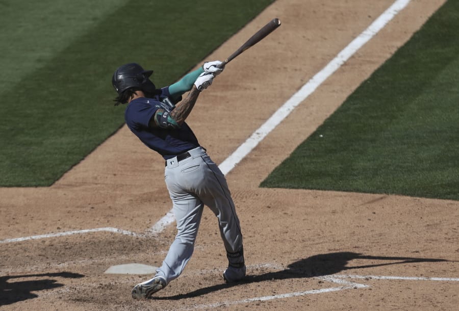 Seattle Mariners&#039; J.P. Crawford hits an RBI-single against the Oakland Athletics during the eighth inning of the first baseball game of a doubleheader in Oakland, Calif., Saturday, Sept. 26, 2020.