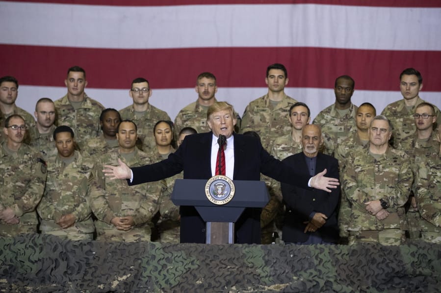 FILE - In this Nov. 28, 2019 file photo, President Donald Trump, center, with Afghan President Ashraf Ghani and Joint Chiefs Chairman Gen. Mark Milley, behind him at right, addresses members of the military during a surprise Thanksgiving Day visit at Bagram Air Field, Afghanistan. During his election campaign four years ago, Trump vowed to bring all troops home from &quot;endless wars.&quot; In recent months he&#039;s only increased the pressure, working to fulfill his campaign promise and get forces home before Election Day.