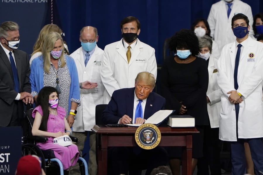 President Donald Trump signs an executive order after delivering remarks on healthcare at Charlotte Douglas International Airport, Thursday, Sept. 24, 2020, in Charlotte, N.C.