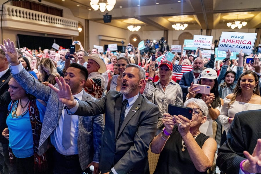 Supporters react as President Donald Trump speaks at a Latinos for Trump Coalition roundtable at Arizona Grand Resort &amp; Spa, Monday, Sept. 14, 2020, in Phoenix.