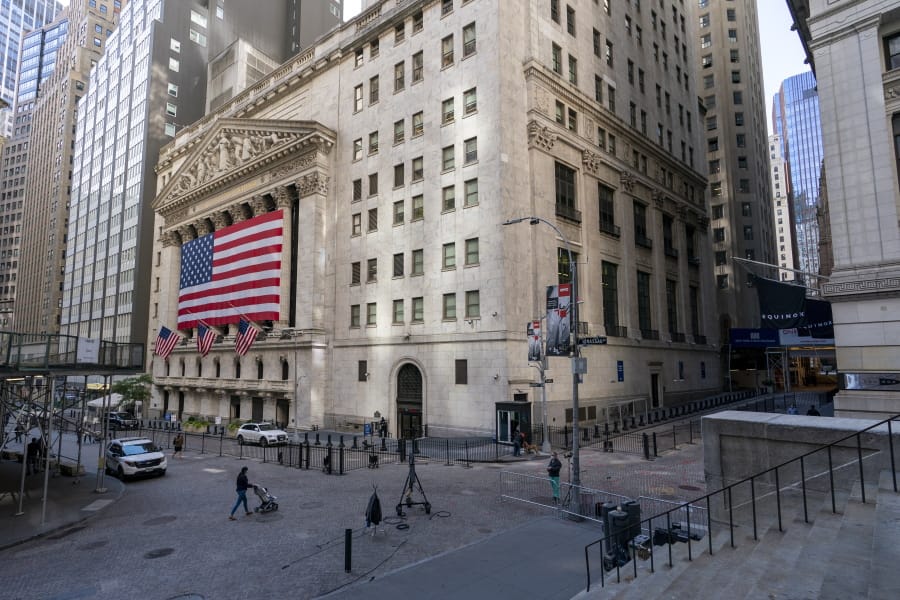 FILE - In this Monday, Sept. 21, 2020 file photo, a giant American Flag hangs on the New York Stock Exchange. Wall Street is rallying Wednesday, Sept. 30 on rising hopes that Washington may pierce through its paralyzing partisanship to offer more aid for the economy.