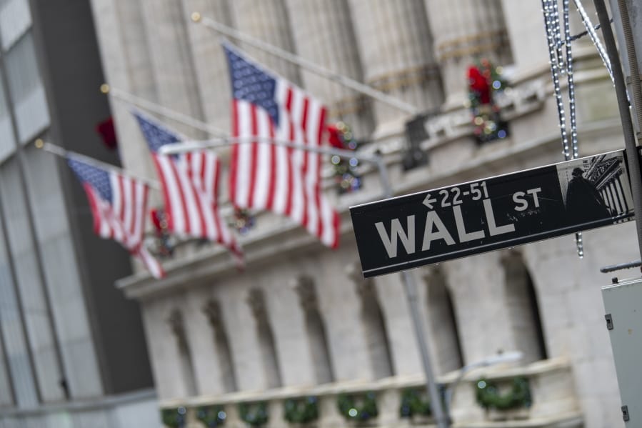 FILE - In this Jan. 3, 2020 file photo, the Wall St. street sign is framed by American flags flying outside the New York Stock Exchange in New York.  Stocks are falling early on Wall Street Thursday, Sept. 17,  as the late selling from the previous day carries over.