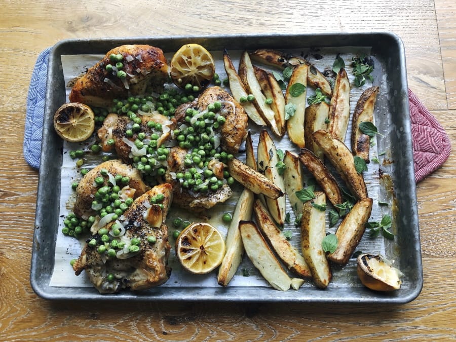 Chicken, potato wedges and green peas prepared in a sheet pan.