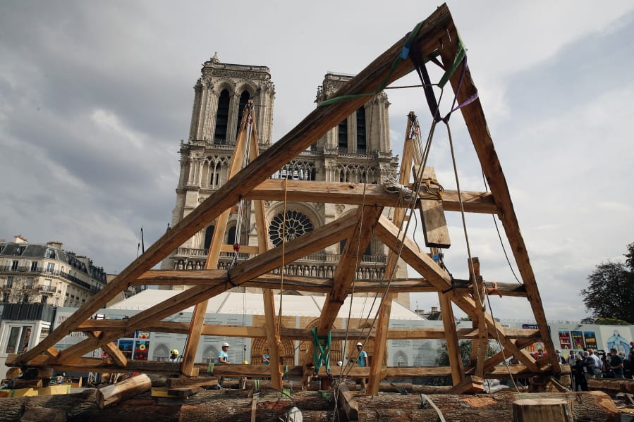 Carpenters put the skills of their Medieval colleagues on show on the plaza in front of Notre Dame Cathedral in Paris, France, Saturday, Sept. 19, 2020, the day honoring European heritage, by reproducing for the public a section of the elaborate carpentry used when the edifice was built. The elaborate wooden beams went up in flames in a devastating April 2019 fire that also toppled the spire of the cathedral, now being renovated.